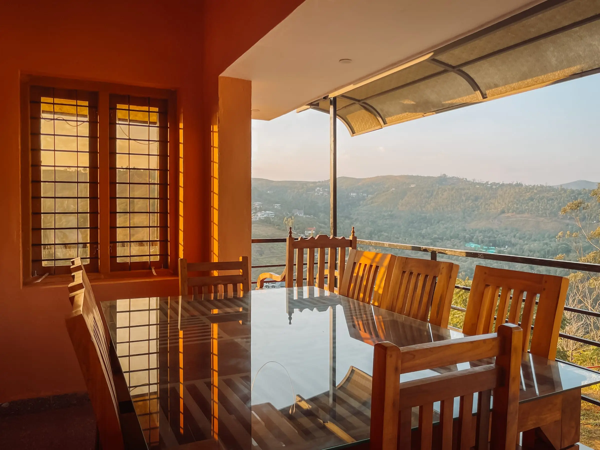 The Spacious Floor: private balcony with a dining table at golden hour, hills beyond